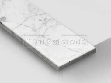 Mramor BIANCO CARRARA, detail. Přírodní kámen původem z Itálie s unikátním bílým zbarvením a decentní nepravidelnou kresbou patří mezi exkluzivní přírodní kameny. Vhodný pro výrobu parapetů do interiérů i exteriérů.