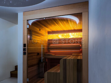 Přírodní kámen onyx, který lze podsvítit, může být luxusním a stylovým doplňkem interiéru. Zde podsvícený HONEY ONYX v sauně. Zakázková výroba kamenictví TONE OF STONE. 