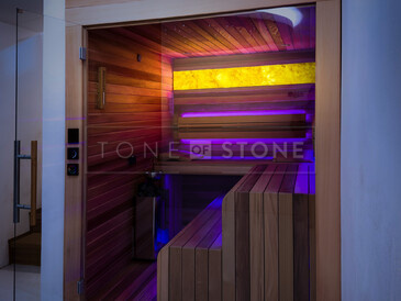 Přírodní kámen onyx, který lze podsvítit, může být luxusním a stylovým doplňkem interiéru. Zde podsvícený HONEY ONYX v sauně. Zakázková výroba kamenictví TONE OF STONE. 