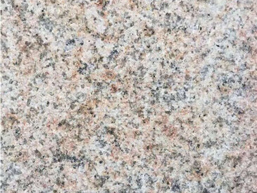 Světlá žula Padang Yellow - detail zrnité struktury a hrubé pískované povrchové úpravy