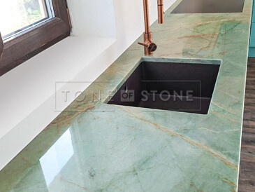 Kuchyňská pracovní deska z přírodního kamene - kvarcit Jadore. Detail pracovní desky, zabudovaného dřezu se spodní montáží a varné desky usazené do roviny. Zakázková výroba kamenictví TONE OF STONE.