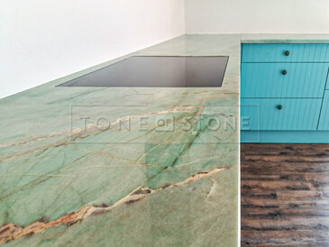 Detail designu pracovní desky z přírodního kamene- kvarcit Jadore, v pozadí varna deska usazena do roviny. Zakázková výroba kamenictví TONE OF STONE.