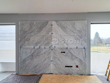 Celkový pohled na obložení stěny mramorem Bianco Carrara. V pravé dolní části jsou umístěny otvory pro zásuvky. Zakázková výroba, kamenictví TONE OF STONE. Celkový pohled na obložení stěny mramorem Bianco Carrara. V pravé dolní části jsou umístěny otvory pro zásuvky. Zakázková výroba, kamenictví TONE OF STONE.