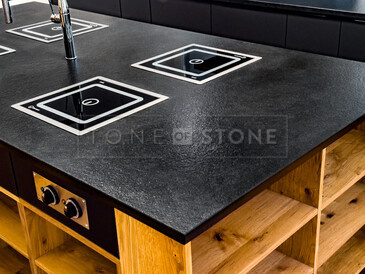 Zasazení indukčních desek do kuchyně s přírodním kamenem Nero Assoluto Zimbabwe v Maternově vile nedaleko Českých Budějovic. Zakázkové kamenictví TONE OF STONE.