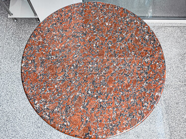Červený kruhový stolek z Kapustinské žuly. Zakázkové kamenictví TONE OF STONE.