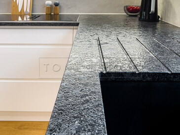 Kuchyňská pracovní deska ze žuly STEEL GREY v kartáčovaném povrchu, vyfrézované odkapové drážky a vsazený dřez. Zakázková výroba kamenictví TONE OF STONE. 