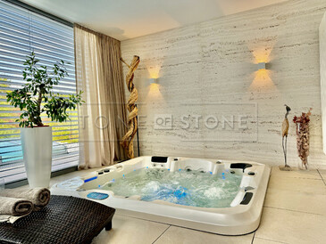 Luxusní spojení přírodního kamene a moderního designu – travertinová stěna podtrhuje klidnou atmosféru wellness zóny v nově zrekonstruovaném domě manželů Hejdových. Zakázková výroba na přání pro manžele Hejdovy. Vyrobeno zakázkovým kamenictvím TONE OF STONE.