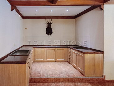 Luxusní kuchyňské desky v prostorách restaurace, kuchyně ve tvaru U v loveckém stylu doplněná o desku z přírodního kamene Multicolor.