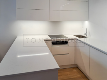 Minimalistická bílá kuchyňská deska z umělého kamene Technistone Noble Supreme White s leštěným povrchem je ideální volbou pro elegantní nadčasové kuchyně. Zakázková výroba TONE OF STONE 