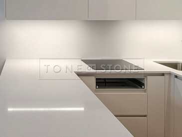 Bílá pracovní deska do kuchyně z umělého kamene Technistone Noble Supreme White v lesklém provedení. Zakázková výroba TONE OF STONE.