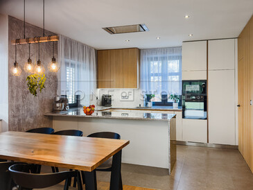 Kamenná kuchyňská deska z šedé žuly Kashmir Silver s kamenným obkladem boku ostrůvku.