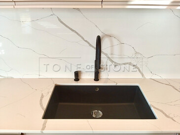 Kamenná pracovní deska z Technistone Crystal Calacatta Silva - černý kuchyňský dřez se spodní montáží a kamenný obklad