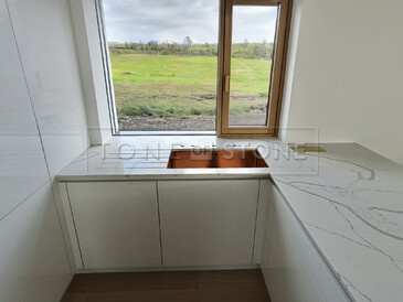 Bílá lesklá kuchyně s pracovní deskou z umělého kamene Techistone Crystal Calacatta Silva včetně dřezu se spodní montáží a vyfrézovaných odkapových drážek. Zakázková výroba TONE OF STONE.