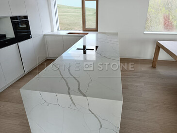 Mramorový vzor Crystal Calacatta Silva, který plynule přechází do boku ostrůvku. Zakázková výroba TONE OF STONE. Mramorový vzor Crystal Calacatta Silva, který plynule přechází do boku ostrůvku. Zakázková výroba TONE OF STONE.