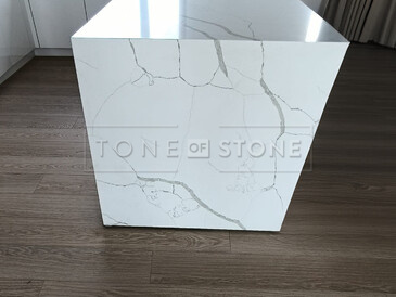 Bok ostrůvku z Technistone Crystal Calacatta Silva plynule navazuje na kresbu pracovní desky. Zakázková výroba TONE OF STONE. Bok ostrůvku z Technistone Crystal Calacatta Silva plynule navazuje na kresbu pracovní desky. Zakázková výroba TONE OF STONE.