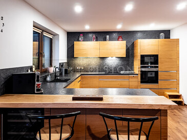 Žulová kuchyňská deska a obklad stěny z přírodního kamene Steel grey s kartáčovanou povrchovou úpravou.  Zakázková výroba TONE OF STONE.