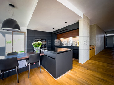 Moderní kuchyně v minimalistickém stylu s kamennou kuchyňskou deskou ze žuly Nero Assoluto Zimbabwe s jemným kartáčovaným povrchem. Zakázková výroba TONE OF STONE.