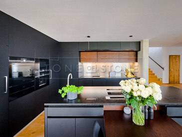Jednotný design černé kuchyně dokonale doplňuje žulová pracovní deska z kamene Nero Assoluto Zimbabwe. Zakázková výroba TONE OF STONE.