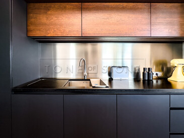 Dřez se spodní montáží a vyfrézovaná odkapová plocha byla součástí realizace pracovní desky do kuchyně z kamene Nero Assoluto Zimbabwe. Zakázková výroba TONE OF STONE. 