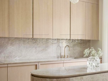 Kuchyňská linka z kvarcitu Taj Mahal v kombinaci s dřevěnými prvky působí harmonicky a nadčasově. Zakázkové kamenictví TONE OF STONE.