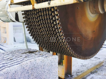 Řez bloku přírodní žuly na formátované desky.