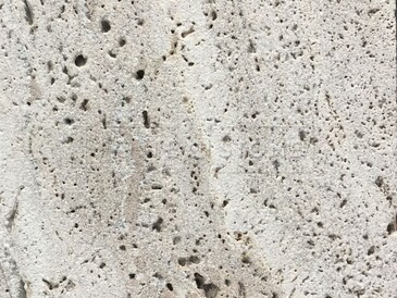 Detail pórovité struktury přírodního kamene Travertino Romano Classico.