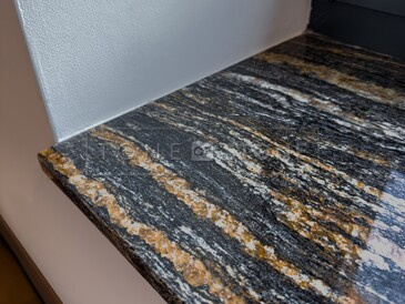 Detail kresby kamenného parapetu ze žuly Magma Black a jejího výrazného žilkování v černo zlatých odstínech