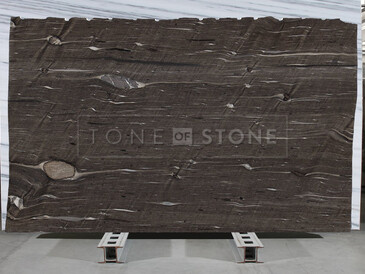 Kámen Brown Silk z čelního pohledu, s výraznou kresbou připomínající texturu dřeva v teplých hnědých tónech. Kámen Brown Silk z čelního pohledu, s výraznou kresbou připomínající texturu dřeva v teplých hnědých tónech.