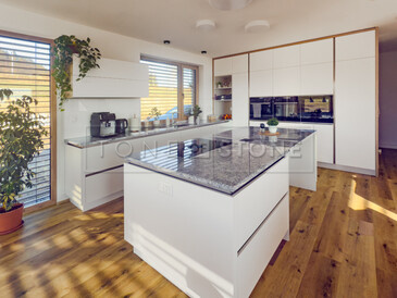 Bílá kuchyně a ostrůvek s šedou kuchyňskou deskou z kamene Viscount White