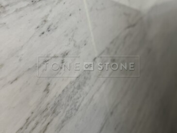 Jemné pravidelné žilkování exkluzivního bílého mramoru Bianco Carrar Extra 