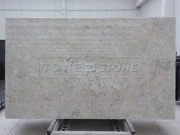 Kamenná deska žuly Colonial White v lesklé povrchové úpravě ve světlých odstínech bílé a krémové Kamenná deska žuly Colonial White v lesklé povrchové úpravě ve světlých odstínech bílé a krémové