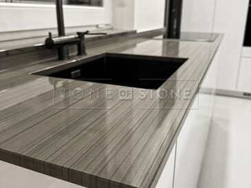 Kamenná kuchyňská deska z šedého kamene Grey Veneer - černý kuchyňský dřez se spodní montáží a kamenný parapet součástí pracovní desky