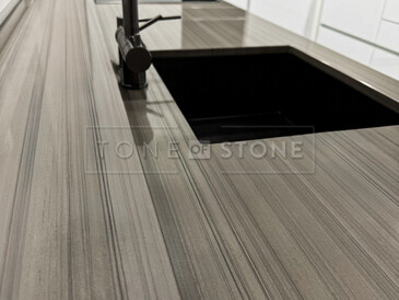 Žulová kuchyňská deska z přírodního kamene Grey Veneer - kamenný parapet součástí kuchyňské desky a černý kuchyňský dřez se spodní montáží