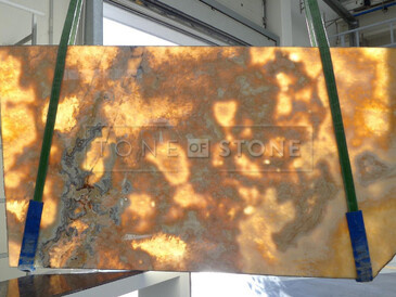 Poloprůsvitná deska z onyxu Onice Miele s jemným žilkováním, vhodná jako obklad stěny nebo kamenný stůl do moderního interiéru. Poloprůsvitná deska z onyxu Onice Miele s jemným žilkováním, vhodná jako obklad stěny nebo kamenný stůl do moderního interiéru.