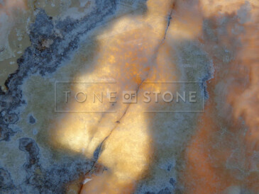 Detailní pohled na přírodní onyx Onice Miele s výraznou strukturou a medovým nádechem, ideální pro luxusní obklady. Detailní pohled na přírodní onyx Onice Miele s výraznou strukturou a medovým nádechem, ideální pro luxusní obklady.