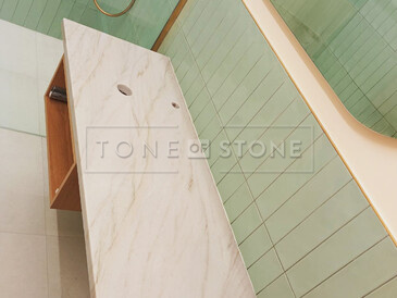 Krémová kamenná koupelnová deska z kvarcitu Sky Gold v moderní koupelně