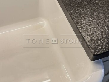 Žulová kuchyňská deska z přírodního kamene Nero Assoluto Zimbabwe s přesahem okolo keramického dřezu