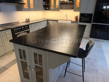 Rustikální kuchyně s ostrůvkem a kamennou kuchyňskou deskou ze žuly Nero Assoluto Zimbabwe