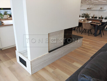 Béžový kamenný obklad krbu z travertinu Travertino Romano CLassico a krbová římsa ze žuly Nero Assoluto Zimbabwe