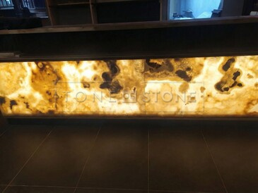 Podsv&iacute;cen&yacute; Onyx Miele jako obklad baru restaurace