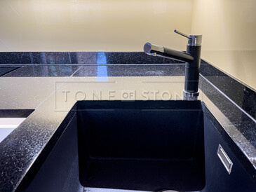 Kuchyňská pracovní deska z přírodního kamene - leštěná černá žula s třpytivými fragmenty - STAR GALAXY, detail přisazeného spodního dřezu a baterie