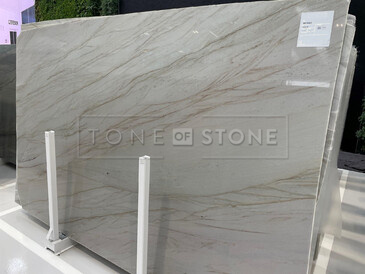 Kvarcit SKY GOLD - velkoformátový přírodní kámen, země původu Brazílie. Velmi oblíben pro svůj výjimečný elegantní vzhled, kterému dominuje béžová barva s decentními šedými a hnědými tony. Jeho použití je velmi univerzální. Pro svou odolnost je vhodný pro výrobu parapetů, koupelnových a kuchyňských desek, výrobu obkladů a dlažeb, obklady krbů a krbových říms, obložení saun nebo pro výrobu designových stolů. Skladem v kamenictví TONE OF STONE.