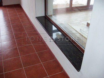 Parapet z přírodního kamene nikdy nevyjde z módy, díky nadčasovému vzhledu může být ozdobou v interiéru i exteriéru - parapet z tmavé žuly 