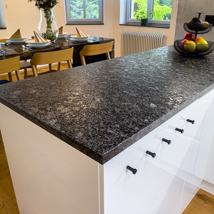 Kuchyňská pracovní deska ze žuly STEEL GREY v kartáčovaném povrchu, vyfrézované odkapové drážky, vsazený dřez, vsazená varná deska. Výroba na zakázku kamenictví TONE OF STONE.