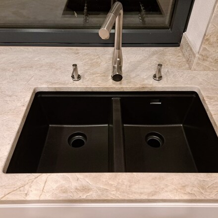 Detail kuchyňské pracovní desky z přírodního kamene a dvojdřezu se spodní montáží. Deska je vyrobena z kvarcitu Taj Mahal. Zakázková výroba kamenictví TONE OF STONE.