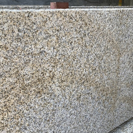 Žula Padang Yellow v &scaron;edo-b&eacute;žov&eacute; barvě s jemnou zrnitou kresbou a hrub&eacute;m p&iacute;skovan&eacute;m povrchu