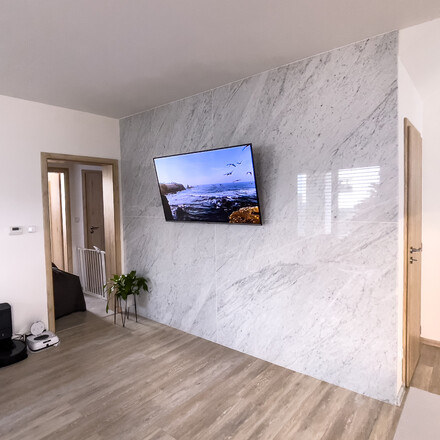 Kamenný obklad stěny z bílého mramoru Bianco Carrara technikou bookmatch