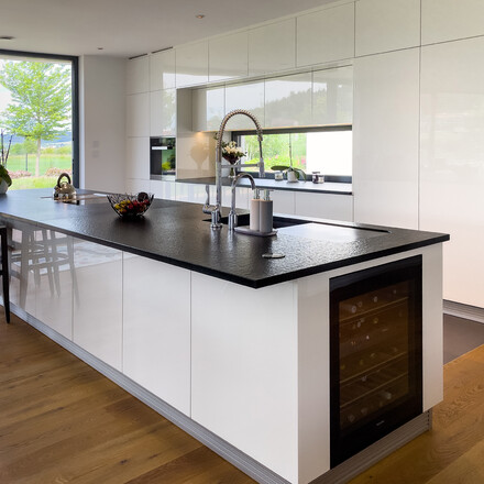 Bílá kuchyně s černou kamennou pracovní deskou ze žuly Nero Assoluto Zimbabwe