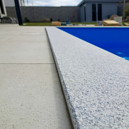 Obklad baz&eacute;nu &scaron;edou žulou Padang Crystal. Zak&aacute;zkov&eacute; kamenictv&iacute; TONE OF STONE.