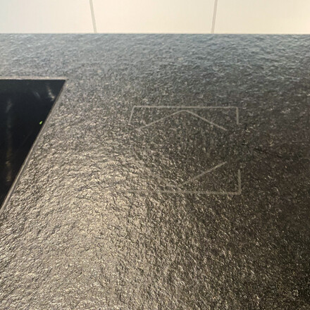 Dotyková plocha pro ovládání žaluzií umístěná na kuchyňském ostrůvku z přírodního kamene Nero Assoluto Zimbabwe